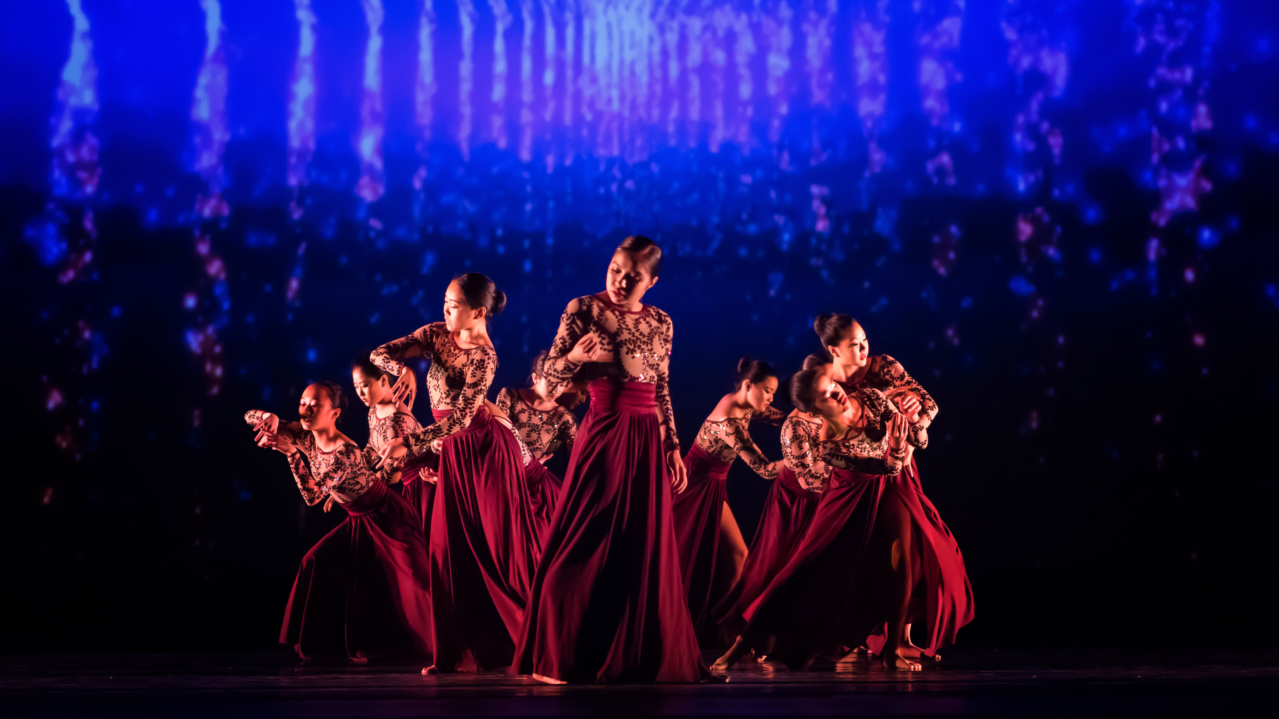 Black and white photo of a group of men performing modern dance on a stage.