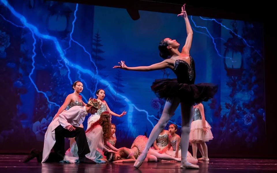 Black and white photo of a group of men performing modern dance on a stage.