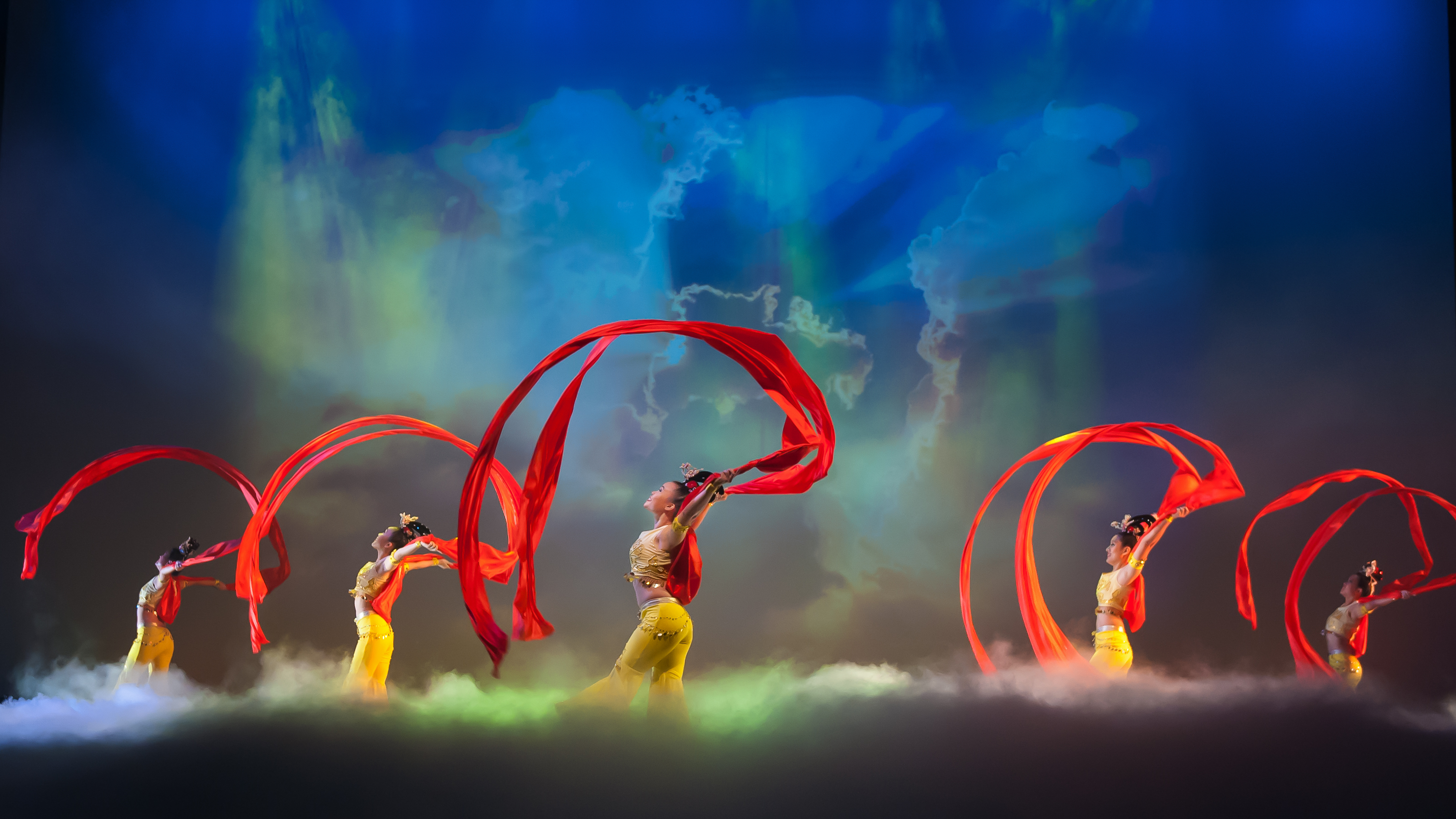 Black and white photo of teens rehearsing a dance routine on a stage.