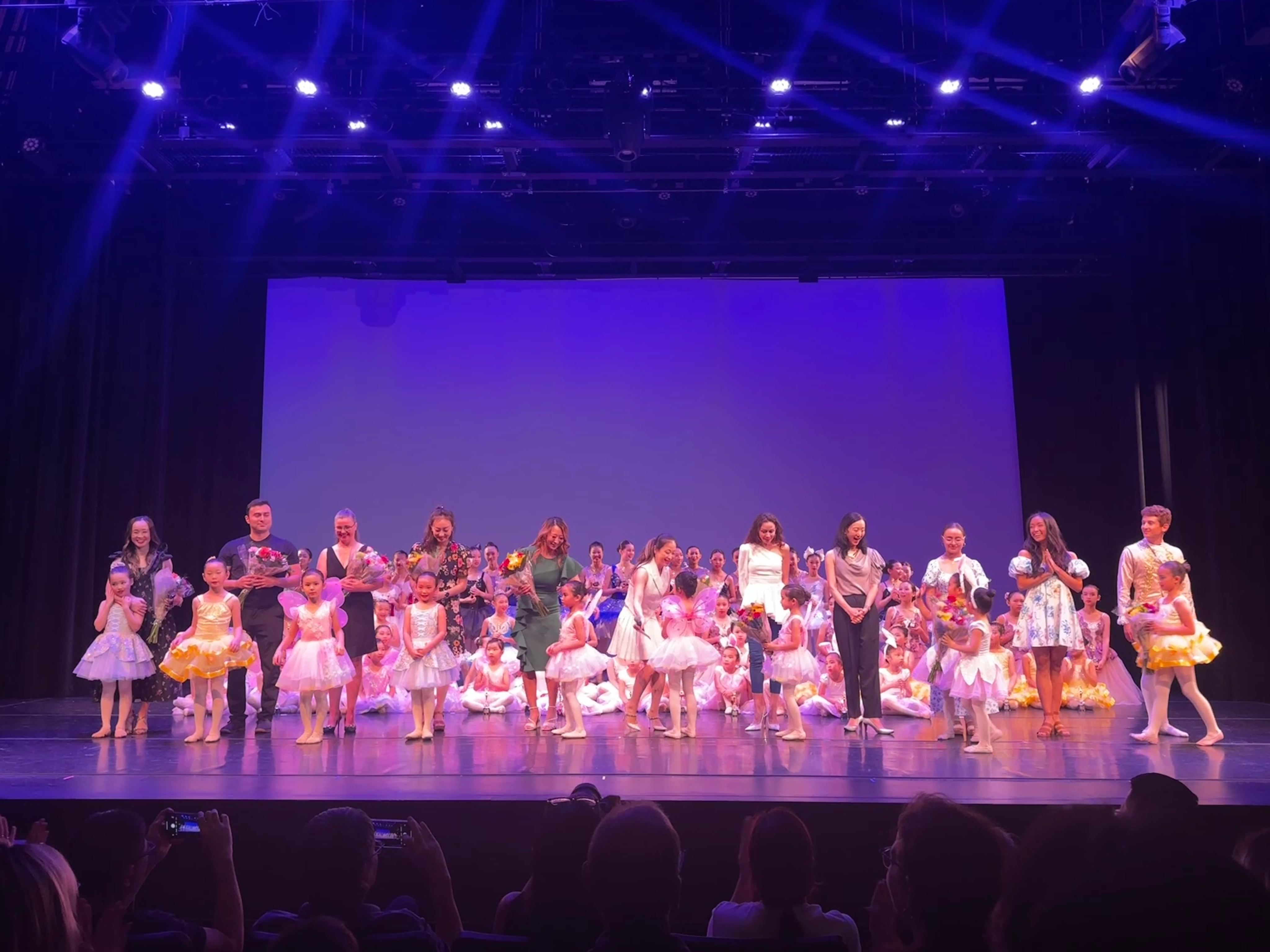 Photo of a group of modern dancers posing on a stage.