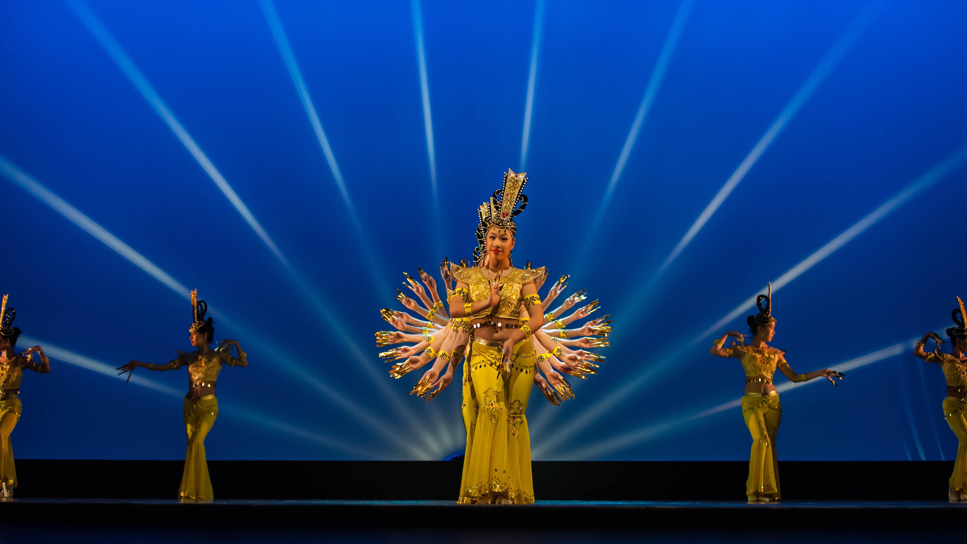 Black and white photo of teens rehearsing a dance routine on a stage.