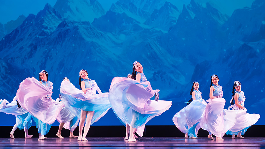 Black and white photo of a group of men performing modern dance on a stage.