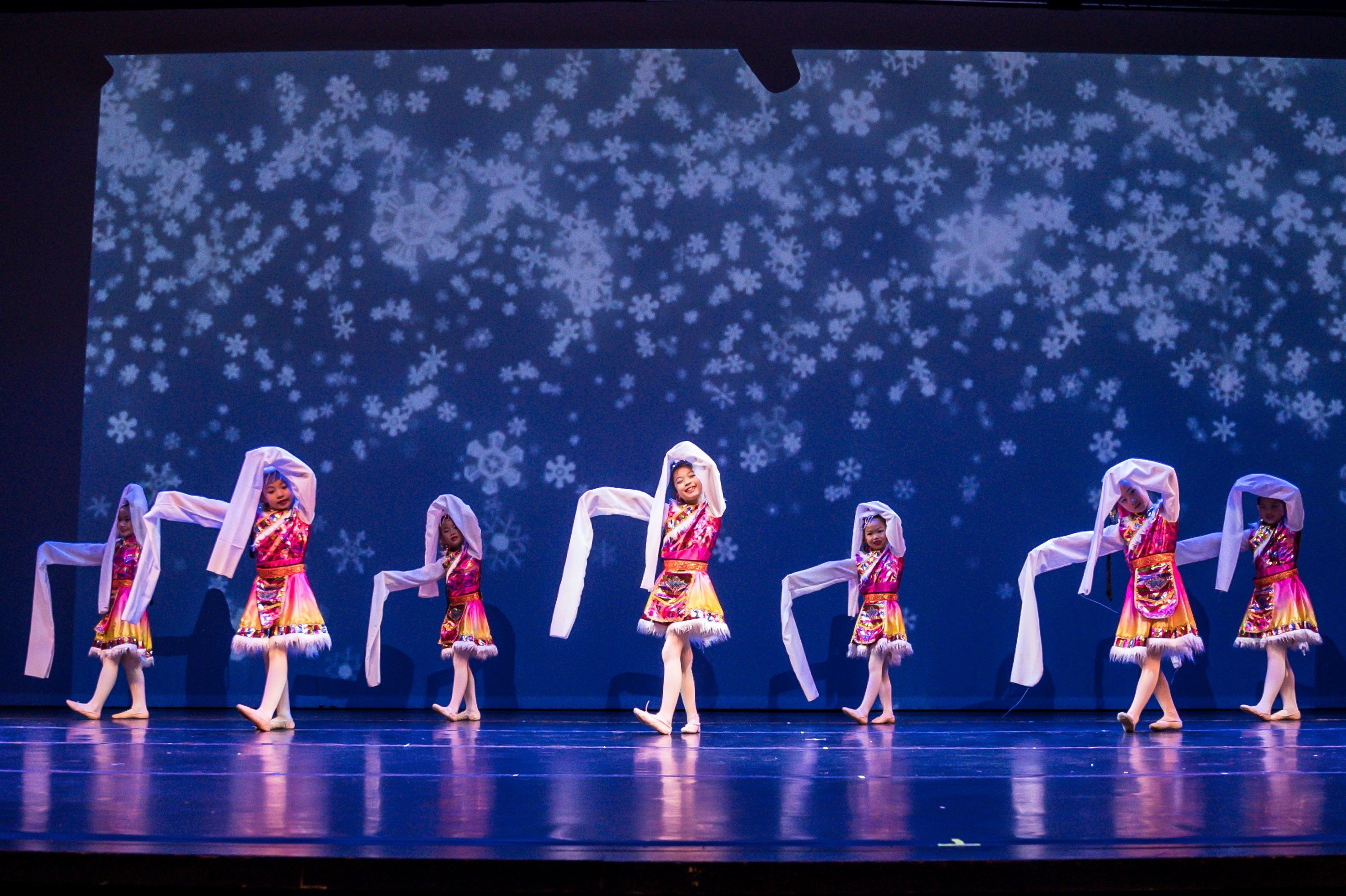 Black and white photo of a women performing modern dance on a dark background.