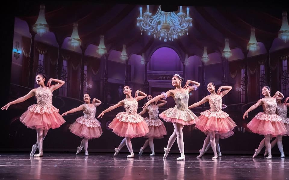 Black and white photo of a group of men performing modern dance on a stage.